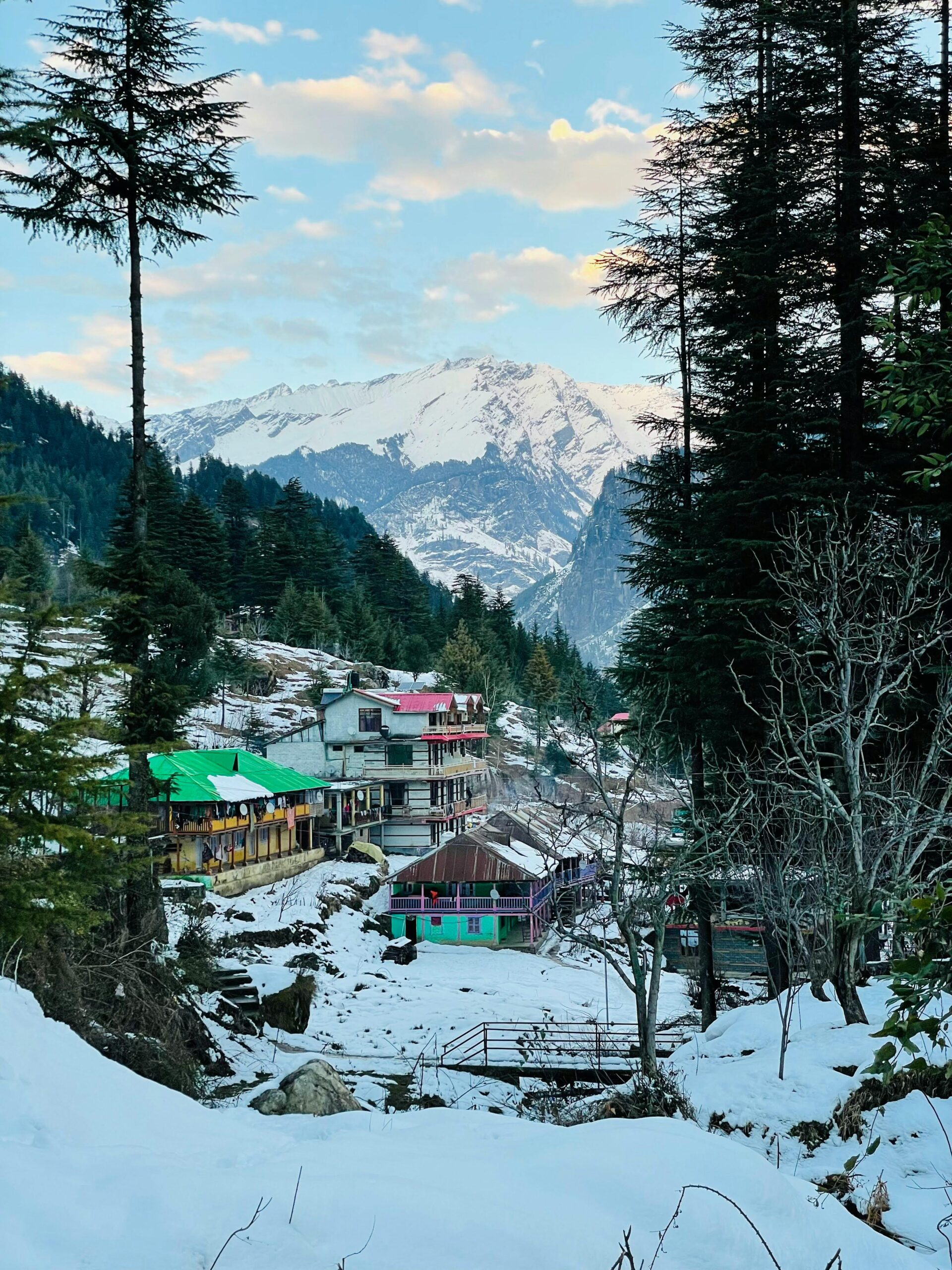 Charming winter view of snow-covered Manali buildings and mountains in Himachal Pradesh.